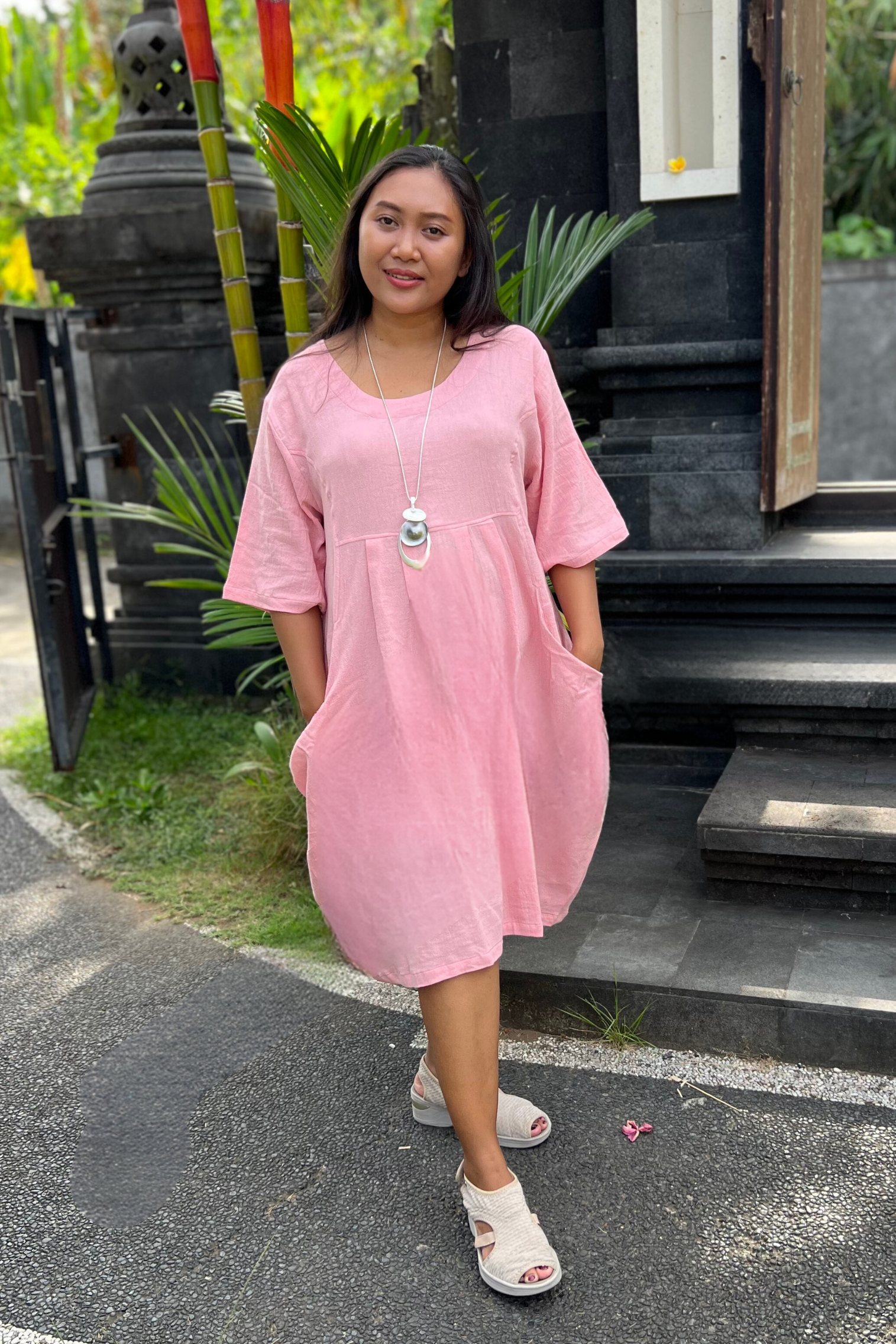 Kita Ku modelling a soft pink cotton dress Isabella in a Balinese setting.