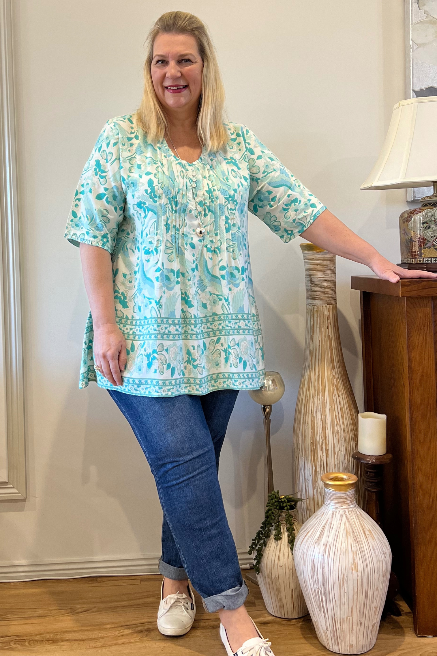 Kita Ku modelling the soft aqua and off white wren print in the top Ebony over jeans and in a lounge setting.