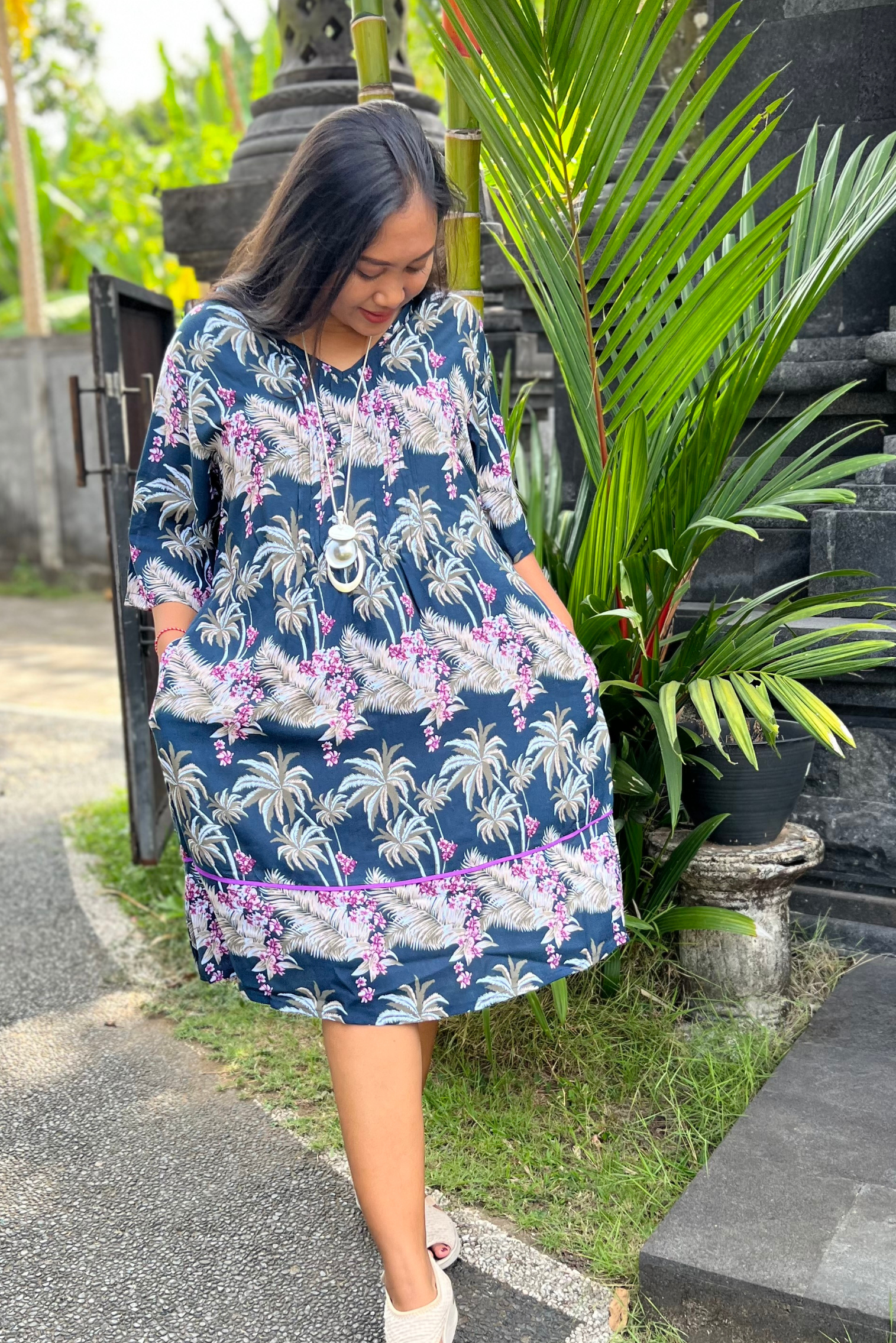 KITAKU MODEL WEARING THE DRESS EMMA IN PALM PRINTED NAVY AND PINK