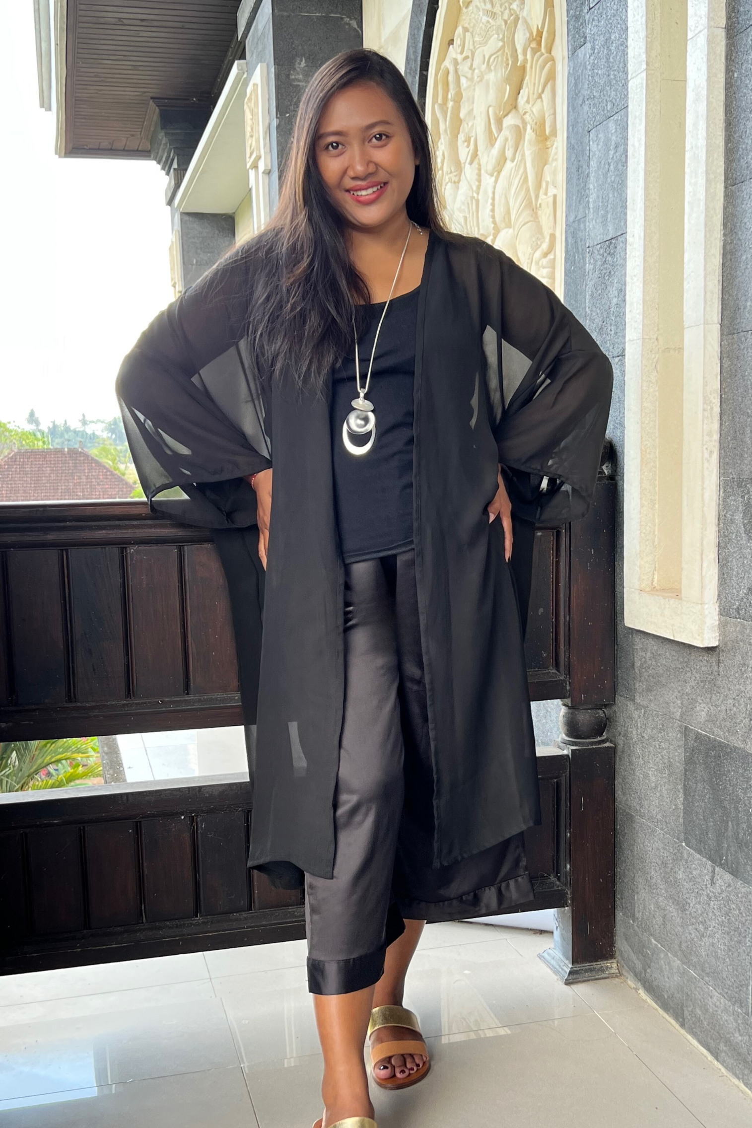Kita ku model wearing a sheer black jacket Janet over black pants and top